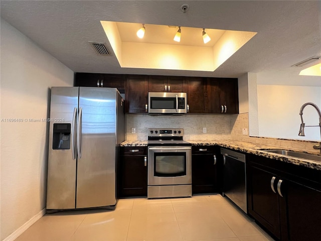 kitchen with decorative backsplash, sink, light stone counters, and stainless steel appliances