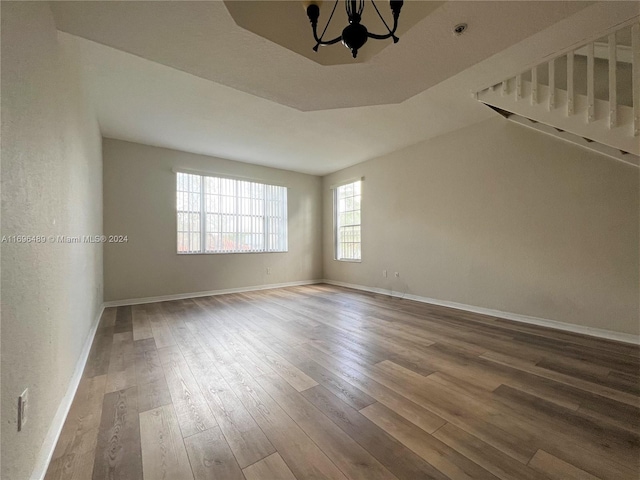 unfurnished room with hardwood / wood-style flooring and an inviting chandelier