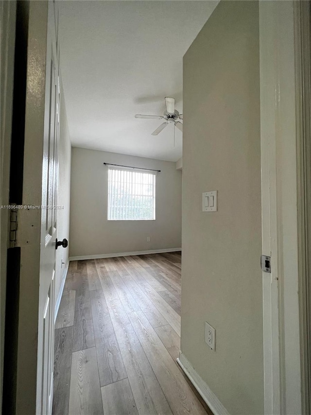 empty room with light hardwood / wood-style flooring and ceiling fan