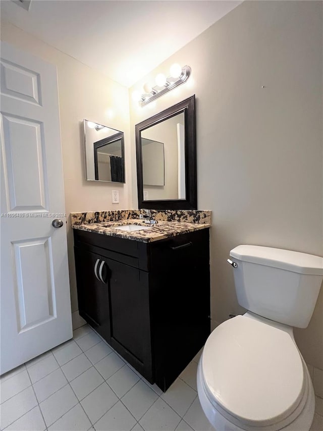 bathroom with tile patterned flooring, vanity, and toilet