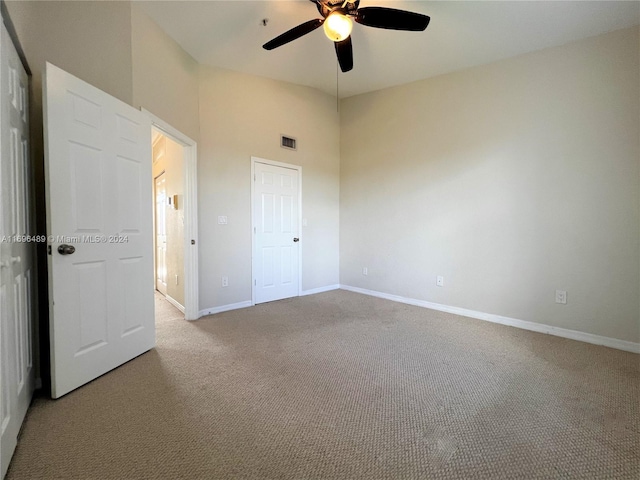 unfurnished bedroom with light colored carpet and ceiling fan