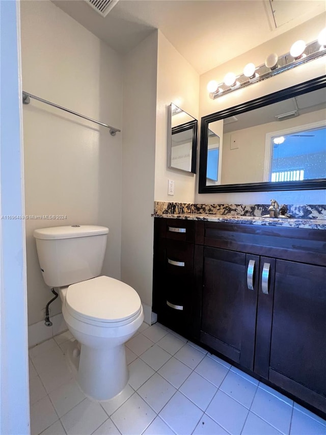 bathroom with tile patterned flooring, vanity, and toilet