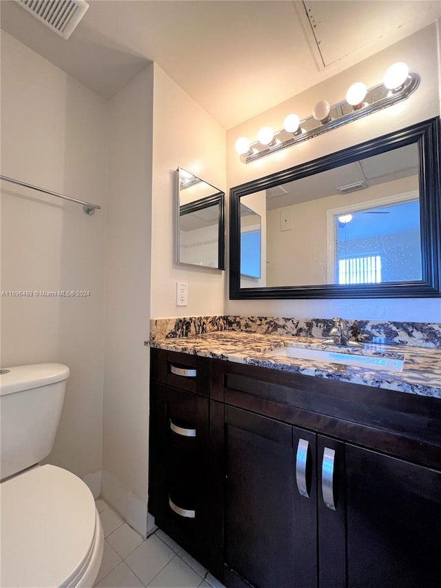 bathroom featuring tile patterned flooring, vanity, and toilet