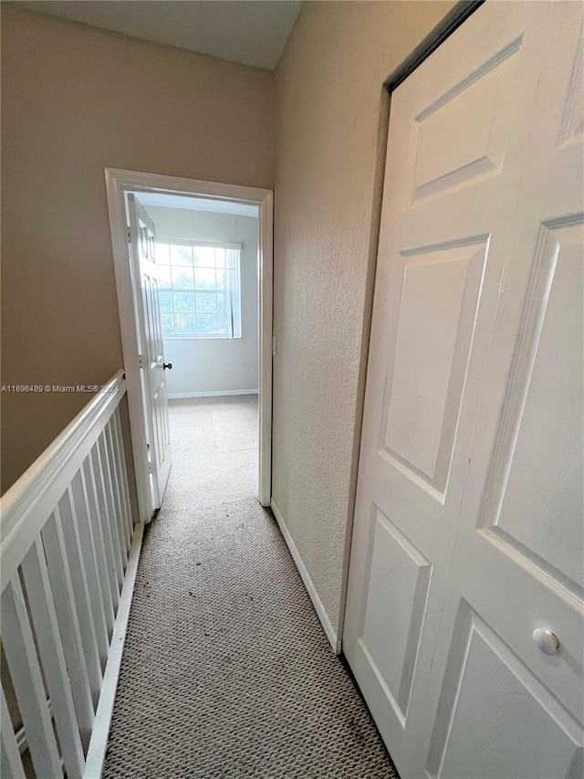 hallway featuring light colored carpet