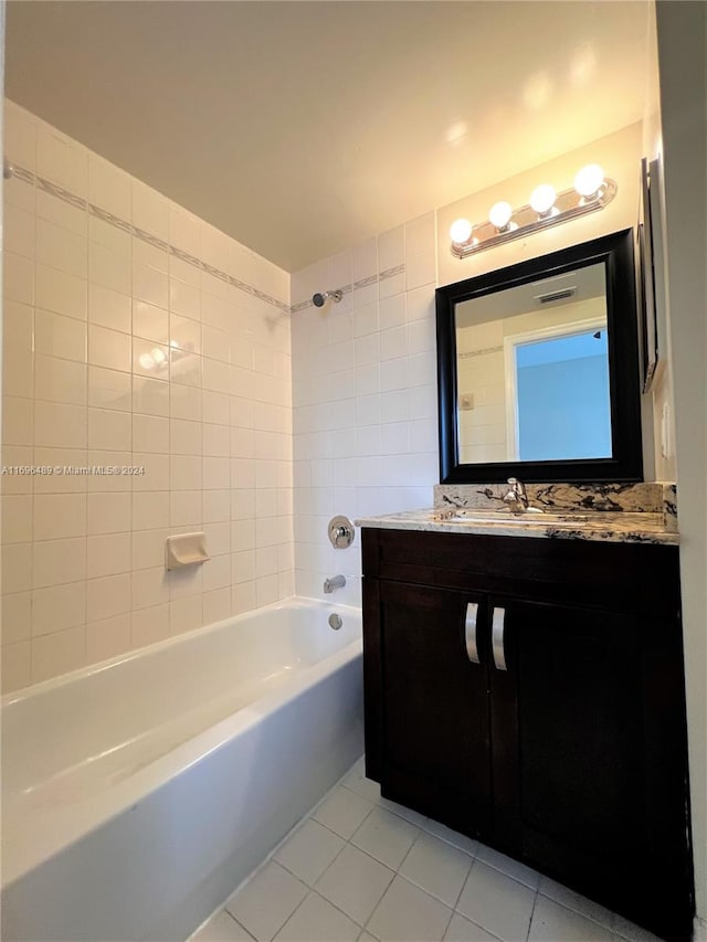 bathroom featuring tile patterned flooring, vanity, and tiled shower / bath