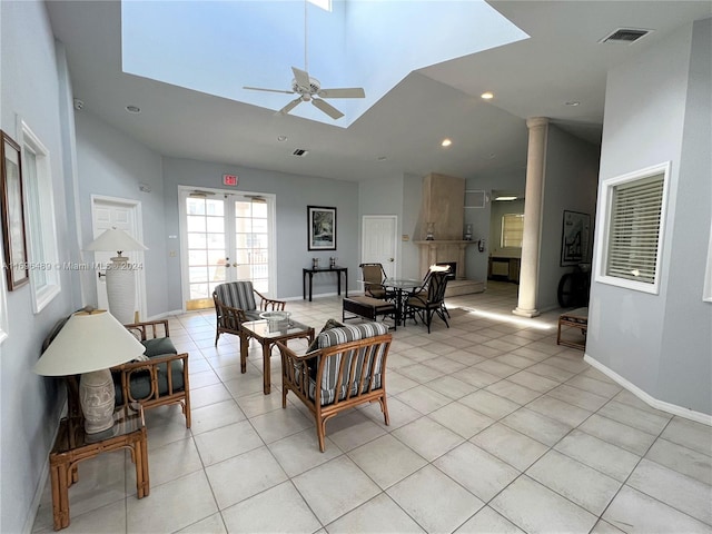 living room featuring ceiling fan, light tile patterned floors, and a high ceiling