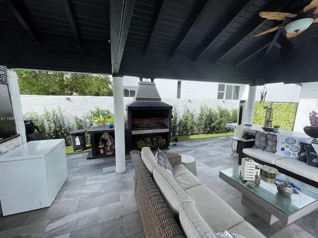 view of patio / terrace with an outdoor living space with a fireplace, a gazebo, and ceiling fan