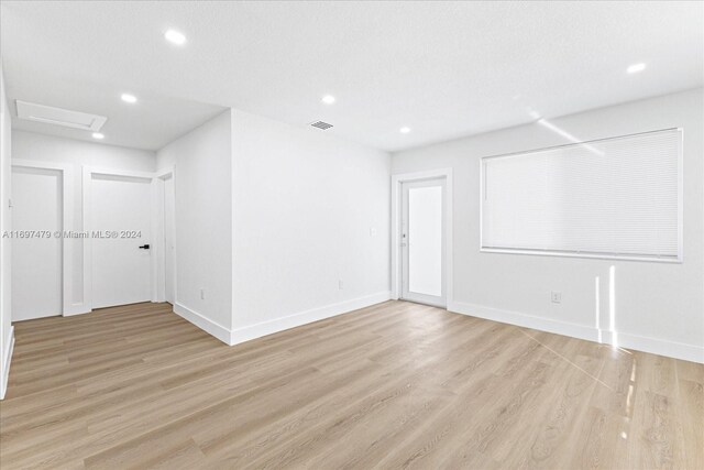 spare room with light hardwood / wood-style flooring and a textured ceiling