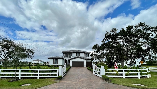 view of front of house featuring a fenced front yard, decorative driveway, a tiled roof, and a garage