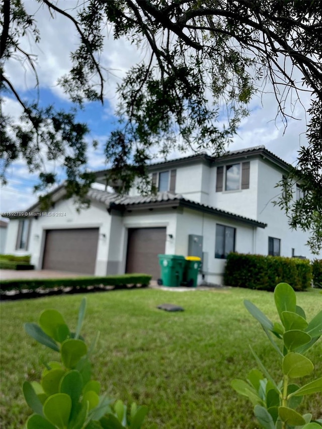 view of front of property with a front yard and a garage