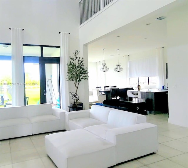 living area with visible vents, a high ceiling, and light tile patterned floors