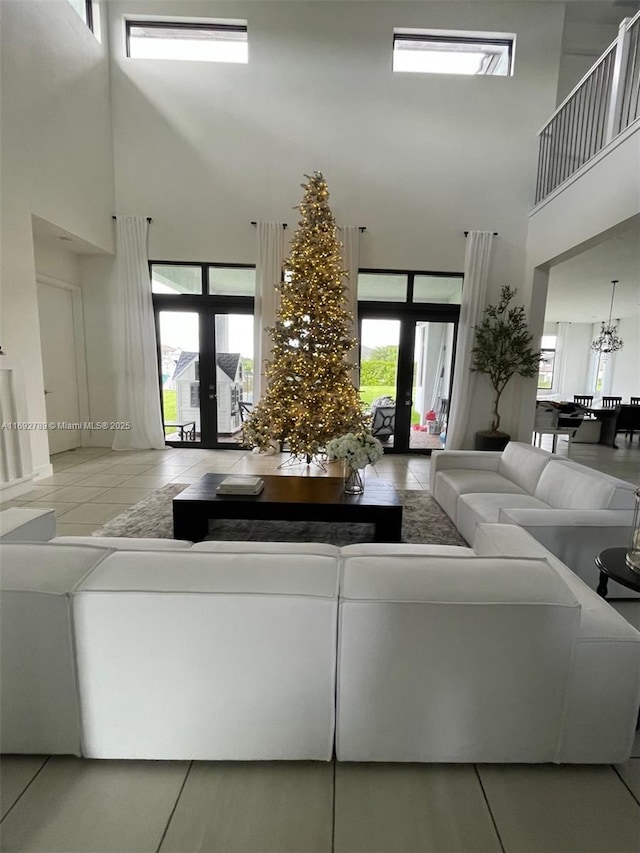 tiled living area with french doors and a towering ceiling