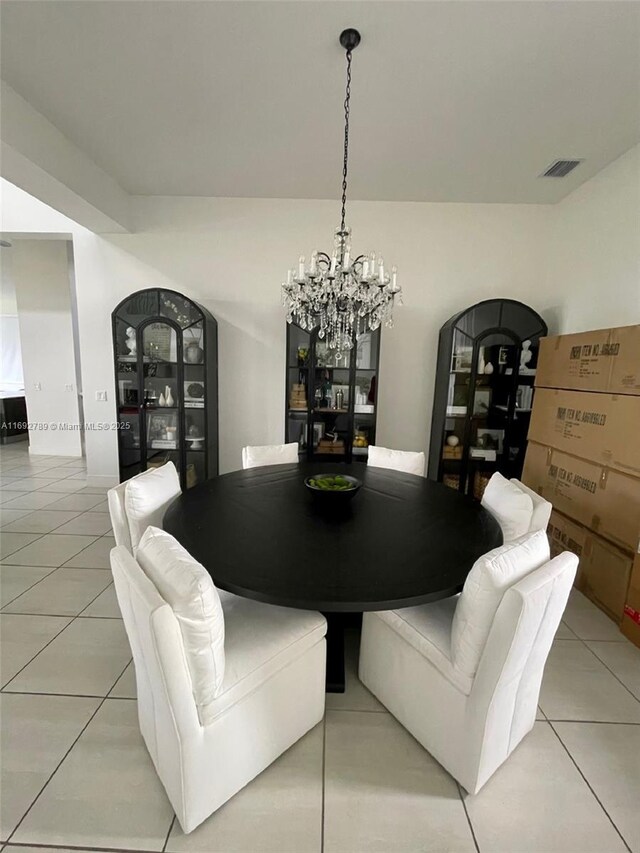 dining area featuring a chandelier, arched walkways, visible vents, and light tile patterned flooring