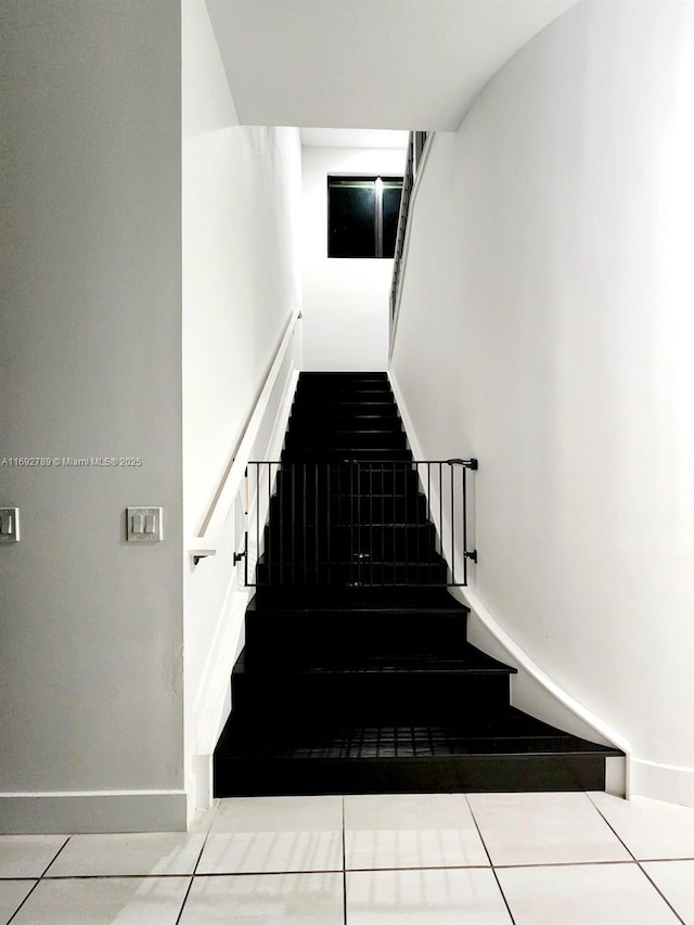 stairs with tile patterned flooring and baseboards