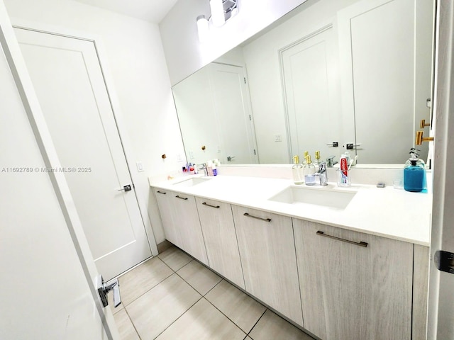 full bathroom with double vanity, a sink, and tile patterned floors