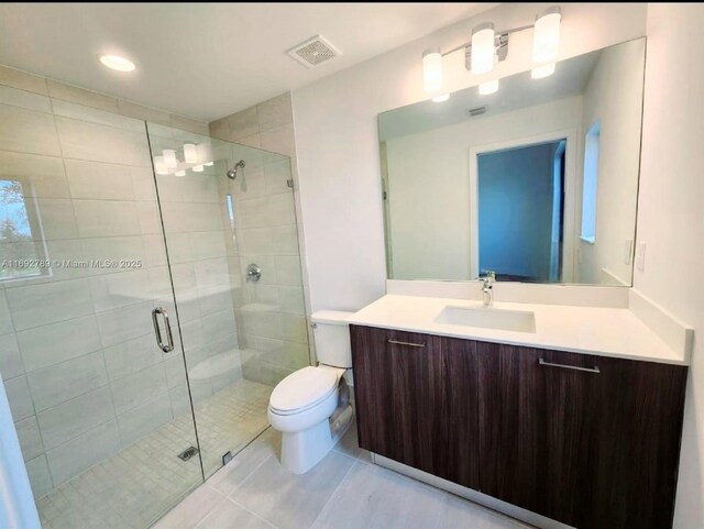 full bathroom featuring visible vents, toilet, a stall shower, vanity, and tile patterned flooring