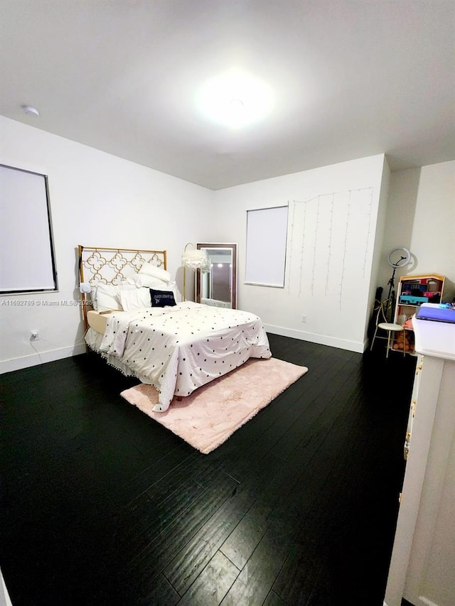 bedroom featuring dark wood-style floors and baseboards