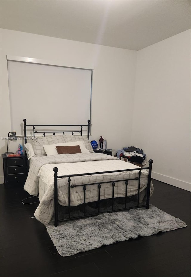 bedroom featuring baseboards and wood finished floors