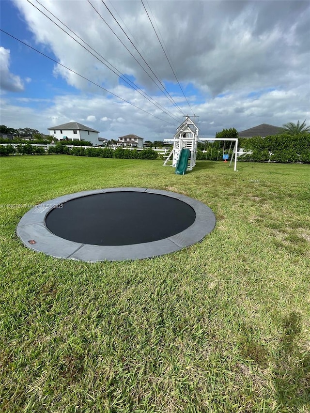 view of yard featuring a trampoline and a playground