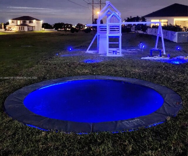 view of swimming pool featuring a hot tub and a playground