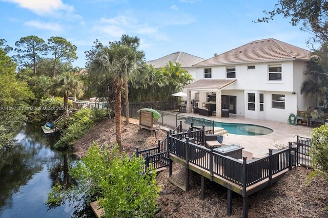 view of swimming pool with outdoor lounge area, a patio area, and a water view