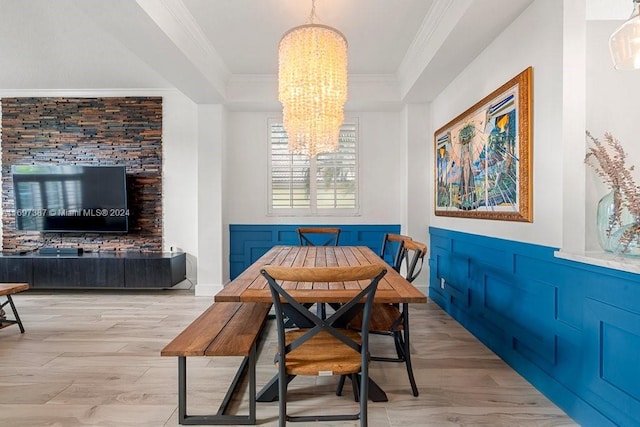 dining area with an inviting chandelier, light hardwood / wood-style flooring, and ornamental molding