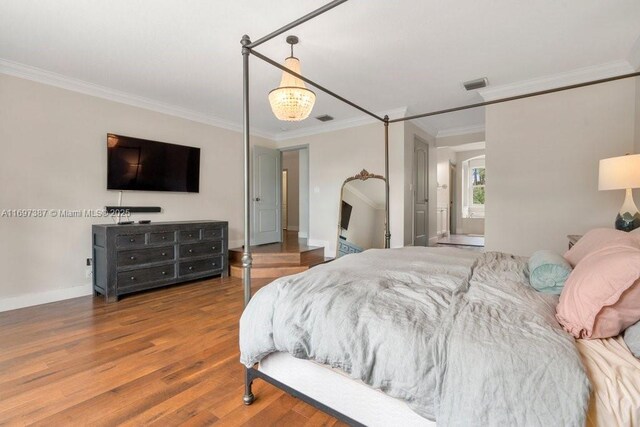 bedroom featuring wood-type flooring and ornamental molding