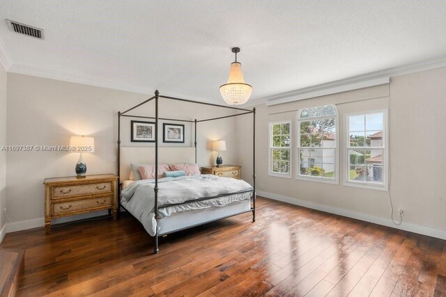 bedroom with dark hardwood / wood-style floors and crown molding