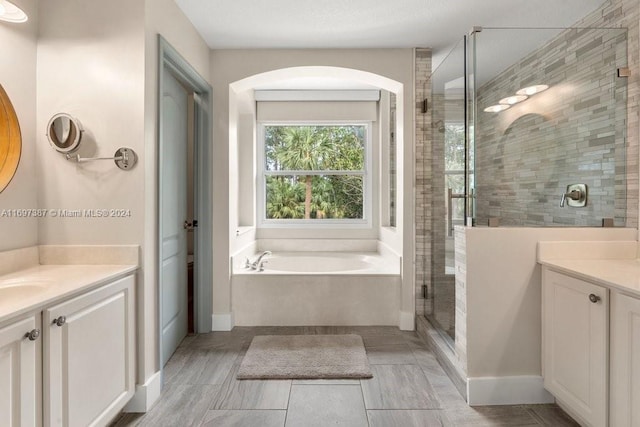 bathroom featuring shower with separate bathtub and vanity