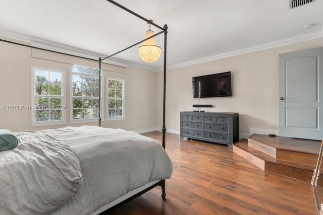 bedroom with wood-type flooring and crown molding