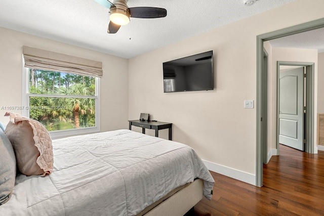 bedroom with ceiling fan, dark hardwood / wood-style flooring, and a textured ceiling