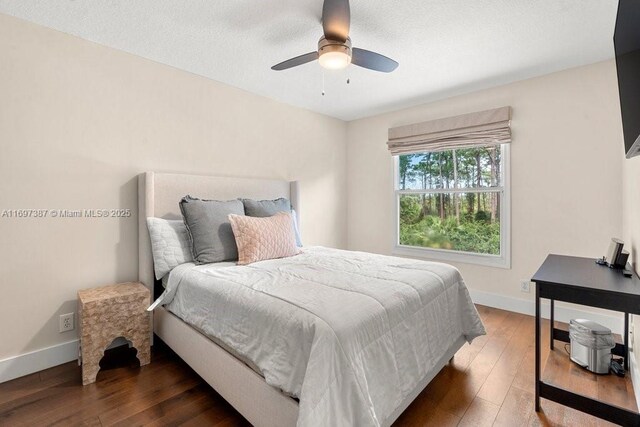 bedroom with ceiling fan and dark wood-type flooring