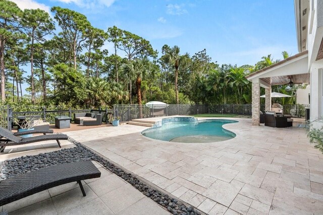 view of swimming pool featuring an outdoor living space, ceiling fan, and a patio area