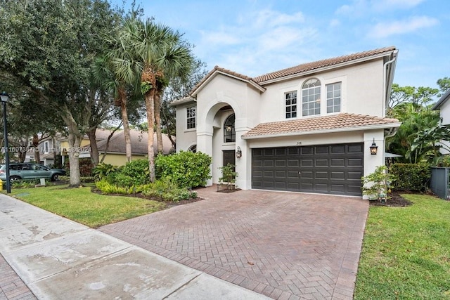 mediterranean / spanish home featuring a garage and a front lawn