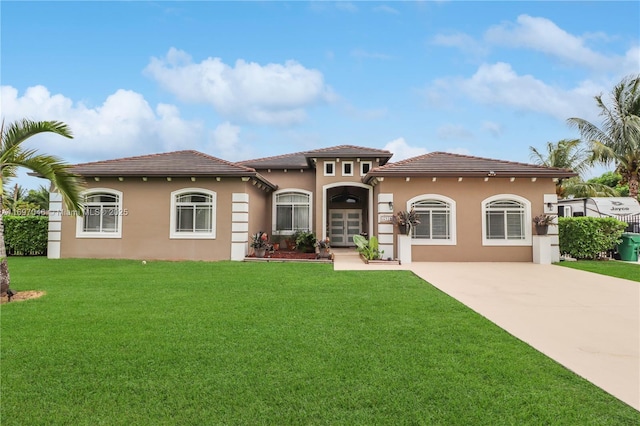 mediterranean / spanish home featuring a front yard and french doors