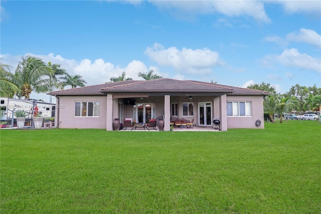 back of property with a patio, ceiling fan, and a lawn