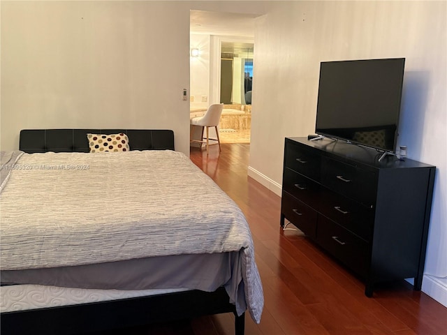 bedroom with dark hardwood / wood-style floors