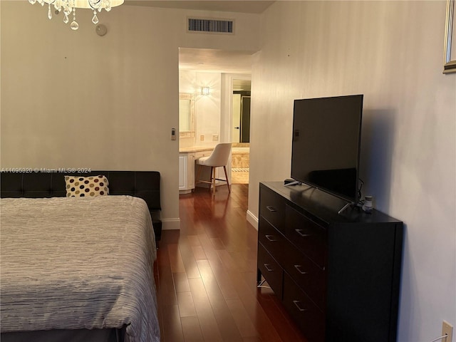 bedroom featuring dark hardwood / wood-style flooring and a chandelier