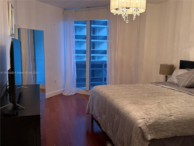 bedroom featuring a notable chandelier and dark hardwood / wood-style flooring