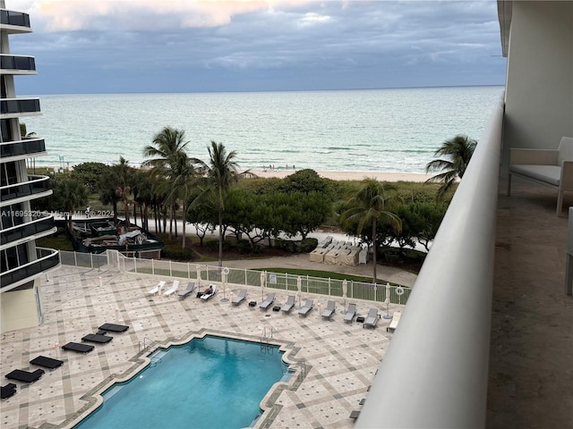 view of swimming pool featuring a water view and a beach view