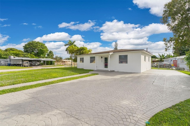 single story home with a front lawn and a carport