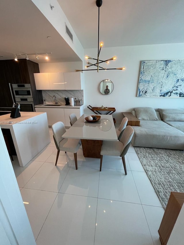 tiled dining area featuring sink and an inviting chandelier