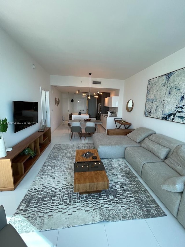 living room with tile patterned floors and a chandelier