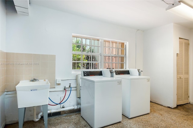 clothes washing area featuring washing machine and clothes dryer and sink