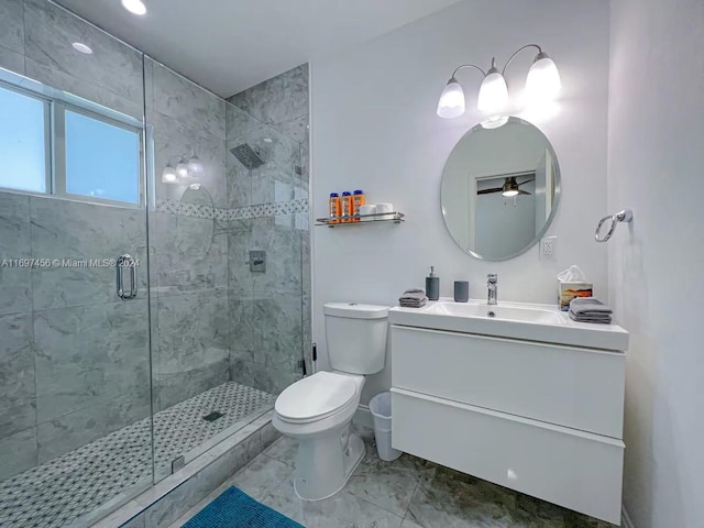 bathroom with ceiling fan, toilet, a shower with shower door, and vanity