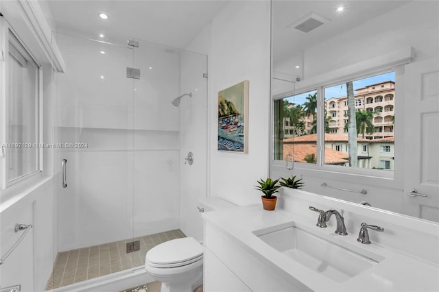 bathroom featuring a shower with door, vanity, and toilet