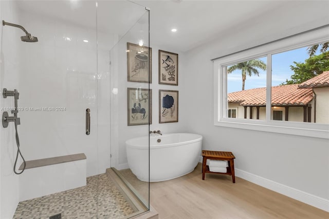 bathroom featuring independent shower and bath and hardwood / wood-style flooring