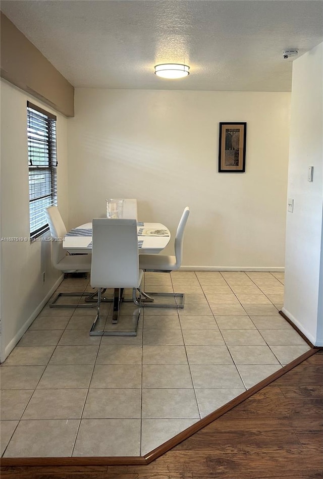 dining space featuring light tile patterned floors and a textured ceiling