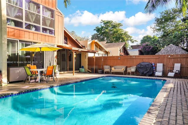 view of pool with area for grilling and a patio area