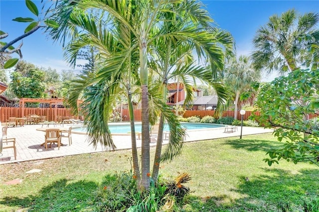 view of community featuring a lawn, a patio area, and a swimming pool